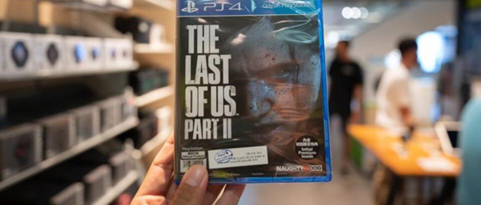 Mão segurando a parte 2 do The Last of Us